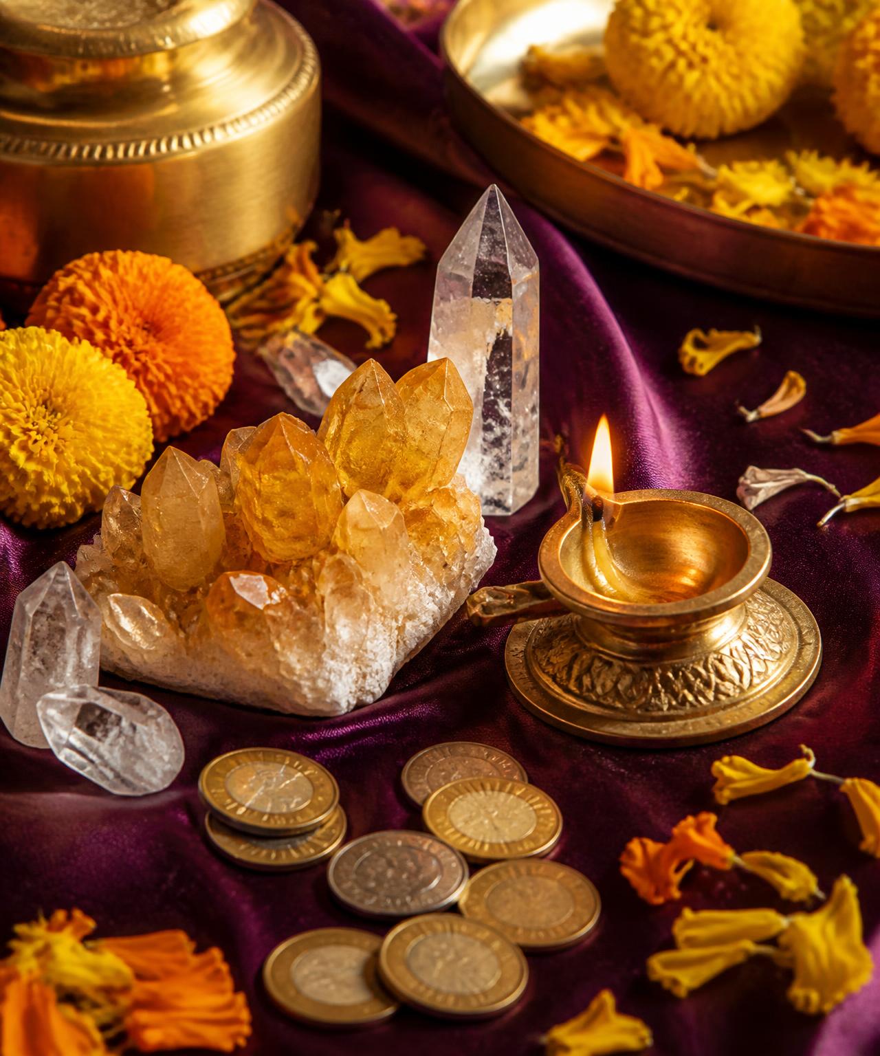 Citrine and clear quartz crystals with a brass diya and ceremonial coins